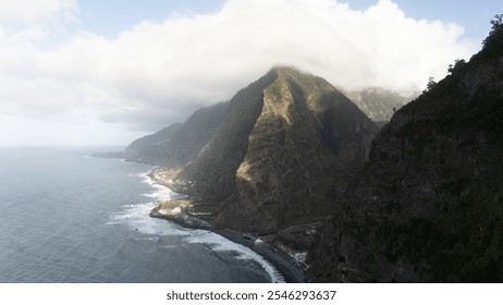 A breathtaking view of rugged coastal mountains enveloped in mist, overlooking the expansive ocean. The scenery evokes a sense of tranquility and natural majesty, showcasing nature's raw beauty. - Powered by Shutterstock