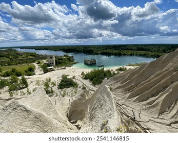 A breathtaking view of the Rummu Quarry in Estonia, showcasing limestone hills, turquoise water, and partially submerged buildings under a dramatic sky, creating a unique and surreal landscape. - Powered by Shutterstock