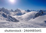 Breathtaking view of the snowy Canadian Rocky Mountains and valley on a sunny winter day. Cold winds sweep the peaks high in Rockies. Panoramic view of snow covered mountain range in British Columbia.