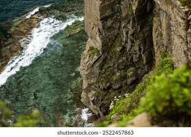 A breathtaking view of a steep cliff that overlooks a vast body of water