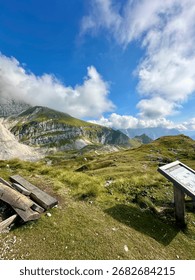 Breathtaking view from the summit of Slovenia’s highest paved road at Mangart Saddle, with rugged peaks of the Julian Alps and a winding mountain road below.