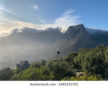 Breathtaking view of Table Mountain covered in clouds during sunrise, showcasing natural beauty and serenity.