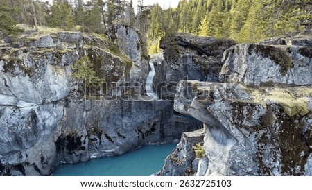 A breathtaking view of a waterfall and the Green River of Nairn Falls Provincial Park, Canada, surrounded by rocky mountains and evergreen forest