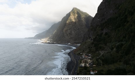 Breathtaking view of a winding coastal road skirting towering cliffs and crashing ocean waves, under a sky with scattered clouds, highlighting nature's raw beauty and tranquility. - Powered by Shutterstock