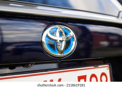 Brecht, Belgium - Februari 5 2022: A Close Up Portrait Of The Toyota Logo On A RAV4 SUV Car Above The Belgian License Plate. The Logo Of The Japanese Manufacturer On The Verhicle Is Chrome And Blue.