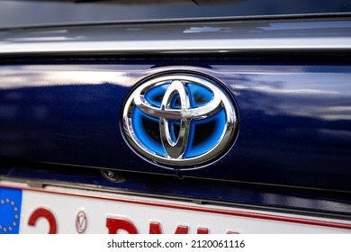 Brecht, Belgium - Februari 5 2022: A Close Up Portrait Of The Toyota Logo On A RAV4 SUV Car Above The Belgian License Plate. The Logo Of The Japanese Vehicle Manufacturer Is Chrome And Blue.