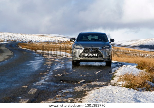 Brecon Beacons, UK: January 30, 2019: A\
Lexus NX 300h F-Sport crossover hybrid car on the road side in snow\
and dangerous icy conditions with copy\
space.