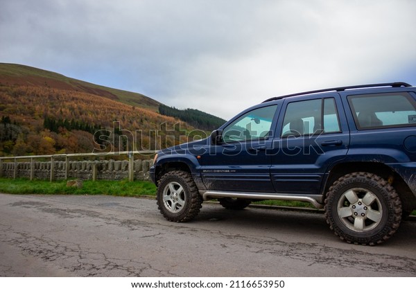 BRECON BEACONS, UNITED KINGDOM - Dec 03, 2021: A\
blue Jeep Grand Cherokee v8 4x4 off-roading in the Brecon beacons,\
South Wales