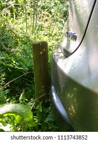 Brecon, UK: May 23, 2018: Near Miss Accident Of A Reversing Car Nearly Bumping The Rear End On A Wooden Fence Pole. Insurance Concept In A Vertical Format. 