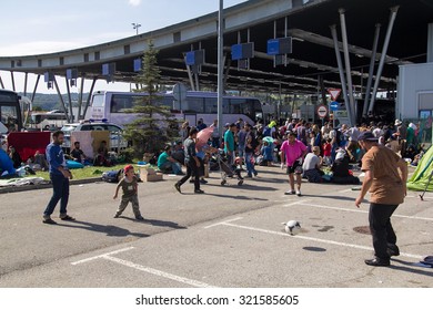 BREGANA, SLOVENIA: SEPTEMBER 19, 2015: Group Of Refugees From Middle East And North Africa At Bregana, State Border Between Slovenia And Croatia.Two Men Playing Football With Little Boy.