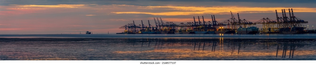 Bremerhaven, Germany - June 14, 2022: scenic sunset panorama of the  overseas port with cranes and container ships