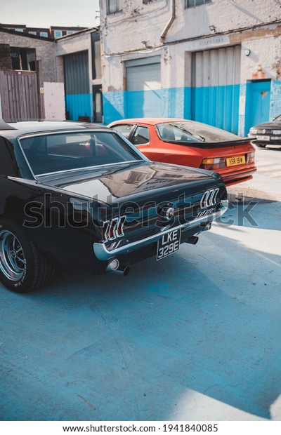 Brentford, West London | UK -  2021.03.21: First\
gneration black vintage Ford Mustang parked at the Brentford\
Projekt parking