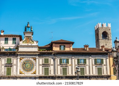 Brescia downtown. Clock and bell tower in Renaissance style, 1540-1550, and medieval Tower of the Broletto Palace called Torre del Pegol. Loggia town square (Piazza della Loggia). Lombardy, Italy.
