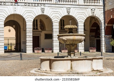 BRESCIA, ITALY - APRIL 17, 2022: Brescia. Medieval Broletto Palace or Government Palace, XII-XXI century. Lombardy, Italy, Europe. Ancient marble fountain and stone arches with keystones and gargoyles