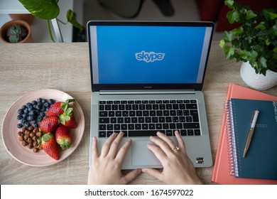 Brescia/Italy - March 2 2020: girl working remote chatting in skype with her laptop and a dish of fresh fruit