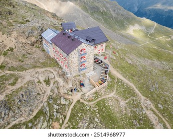 The Breslauer Hut rests peacefully in the Otztal Alps, surrounded by rugged mountain terrain. Visitors gather outside, enjoying the breathtaking alpine views during a sunny day in the Austrian - Powered by Shutterstock