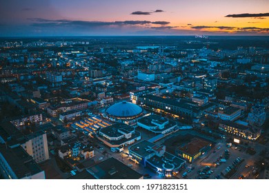 Brest, Belarus. Aerial Bird's-eye View Of Brest Cityscape Skyline. Bird's-eye View Of Brest Market In Evening Illuminations.
