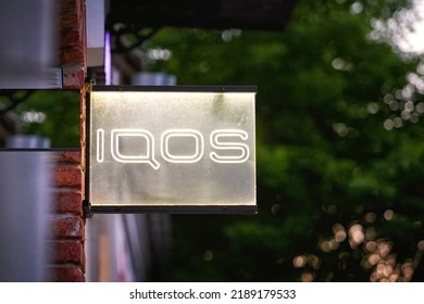 Brest, Belarus. Jun 2022. Sign IQOS Glowing In Evening. Neon Company Signboard IQOS On Shop Window. IQOS Of Philip Morris International - Boutique Of Heated Tobacco Smoking Devices. 