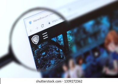 Brest, Belarus, March 15, 2019. The Home Page Of The Warner Brothers Website, View Through A Magnifying Glass. Warner Brothers Company Logo Is Visible. Soft Focus.