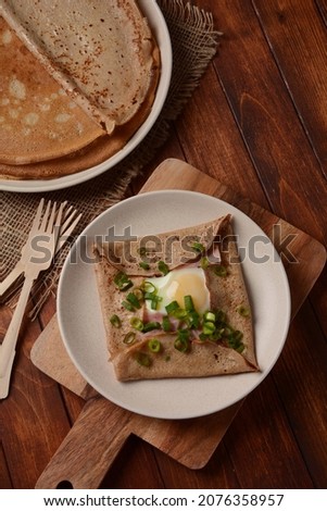 Breton galette, galette sarrasin, buckwheat crepe, with fried egg, cheese, ham. French Brittany cuisine. 
