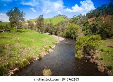 Bretti reserve, Barnard River, New South Wales, Hunter Valley, Australia. River meanders through green rolling hills red cliffs and sparse woodland.