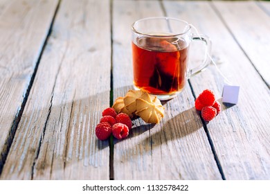 brewed in cup of tea. on wooden table lies cookie and ripe raspberries - Powered by Shutterstock