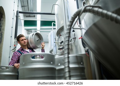 Brewer Carrying Keg At Brewery Factory