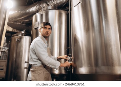 Brewer filling beer in bottle from tank at brewery - Powered by Shutterstock