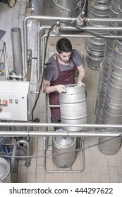 Brewer Moving Kegs In Brewery