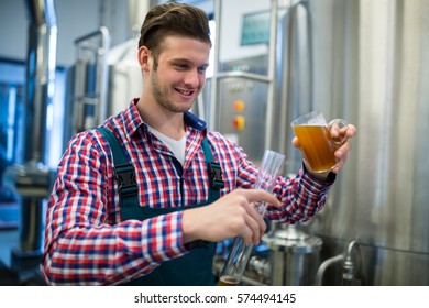 Brewer pouring beer in hydrometer cylinder at brewery factory - Powered by Shutterstock