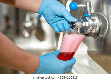 Brewer pouring freshly brewed craft beer from tank - Powered by Shutterstock