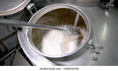 Brewer Is Stirring Malt Inside Vat During Brewing In Modern Plant, Detail View, Using Paddle, Manual Labor