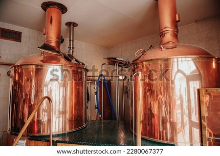 brewery, copper vats with beer. View of beer brewery interior with traditional fermenting copper vats. Modern brewery. Craft beer production line. Copper tanks for brewing