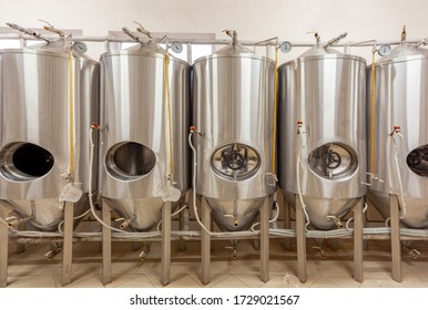 Brewery, five beer tanks, cylinder-conical fermentation tanks, open in three hatchways, closed in two others - Shutterstock ID 1729021567