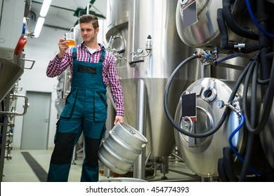 Brewery Holding Keg And Testing Beer At Brewery Factory