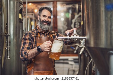 Brewery master tasting beer in production facility. Small family business, production of craft beer. - Powered by Shutterstock