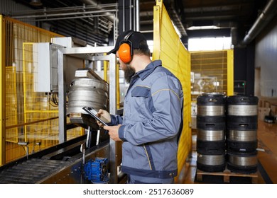 Brewery technologist, in full protective gear, carefully inspecting the production area, highlighting importance of safety and quality. Concept of beer, brewery, manufacture, quality control - Powered by Shutterstock