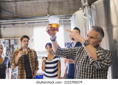 Brewery tour guide pointing to beer in beaker - Powered by Shutterstock