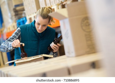 brewery worker checking bottle of beer in cardboard box - Powered by Shutterstock