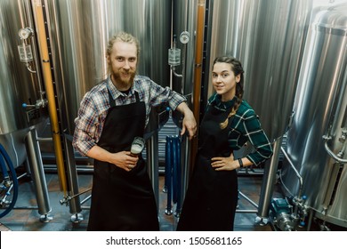 Brewery workers looking at freshly made beer in glass tube and discussing it. Male and female brewer testing beer at brewery factory. 4k. Small business concept. - Powered by Shutterstock