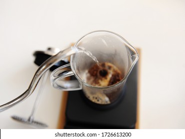 Brewing coffee in french press. Pouring hot water close up. Top view. White background. Gooseneck kettle - Powered by Shutterstock