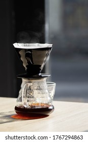 brewing coffee in a funnel. the hario v60 coffee funnel is on the server. beautiful table with dark background. the process of brewing the coffee specialty. steam comes from the coffee - Shutterstock ID 1767294863