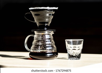 brewing coffee in a funnel. the hario v60 coffee funnel is on the server. beautiful table with dark background. the process of brewing the coffee specialty. steam comes from the coffee - Shutterstock ID 1767294875