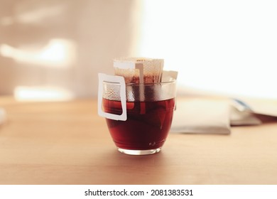 Brewing coffee in a glass with drip bag on a wooden table