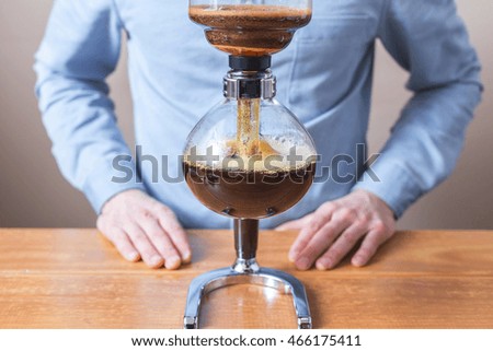 brewing coffee siphon. step by step cooking instructions. waiting for the extraction process. brewed coffee flows from top to bottom of the vessel