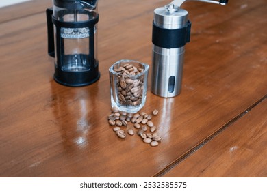 Brewing method French press coffee maker, with Manual Grinder, french press and glass of coffee beans on the wooden table, making coffee homemade. - Powered by Shutterstock