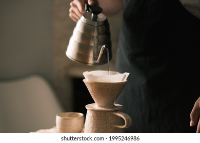 Brewing pourover coffee in the kitchen, pouring hot water on the - Shutterstock ID 1995246986