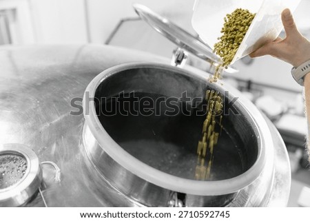 Brewing process in action, adding hops to beer fermentation tank.