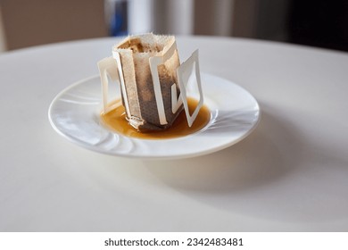 brewing process,a bag filled with boiling water for drip coffee in a cup,top view