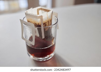 brewing process,a bag filled with boiling water for drip coffee in a cup,top view